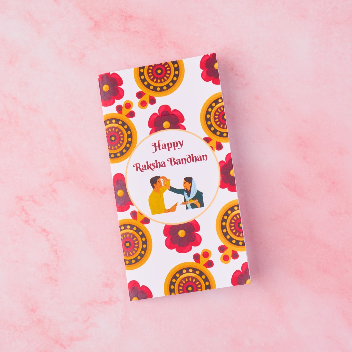 Traditional Raksha Bandhan roli chawal tilak set with red-yellow floral card and brother-sister illustration