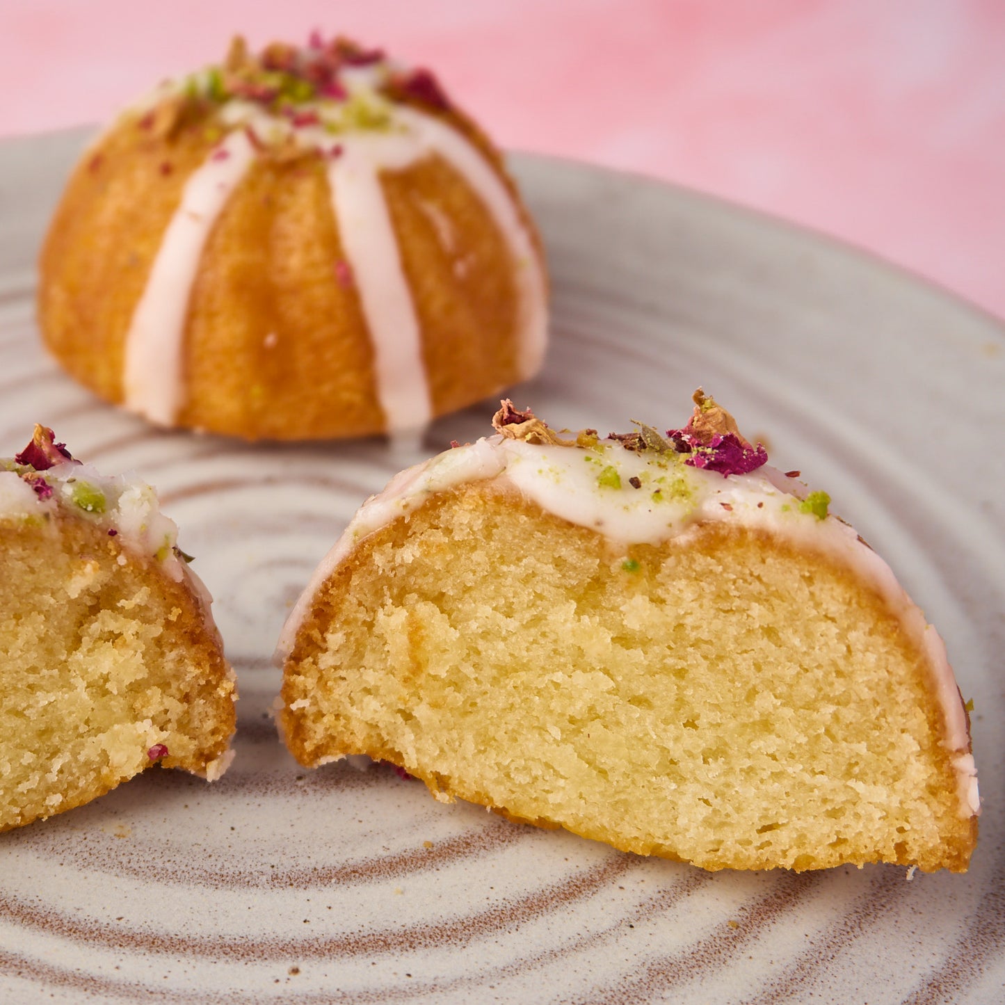 Inside view of Eggless Mini Gulab Jamun Tea Cake - soft, moist centre with rose and pistachio garnish