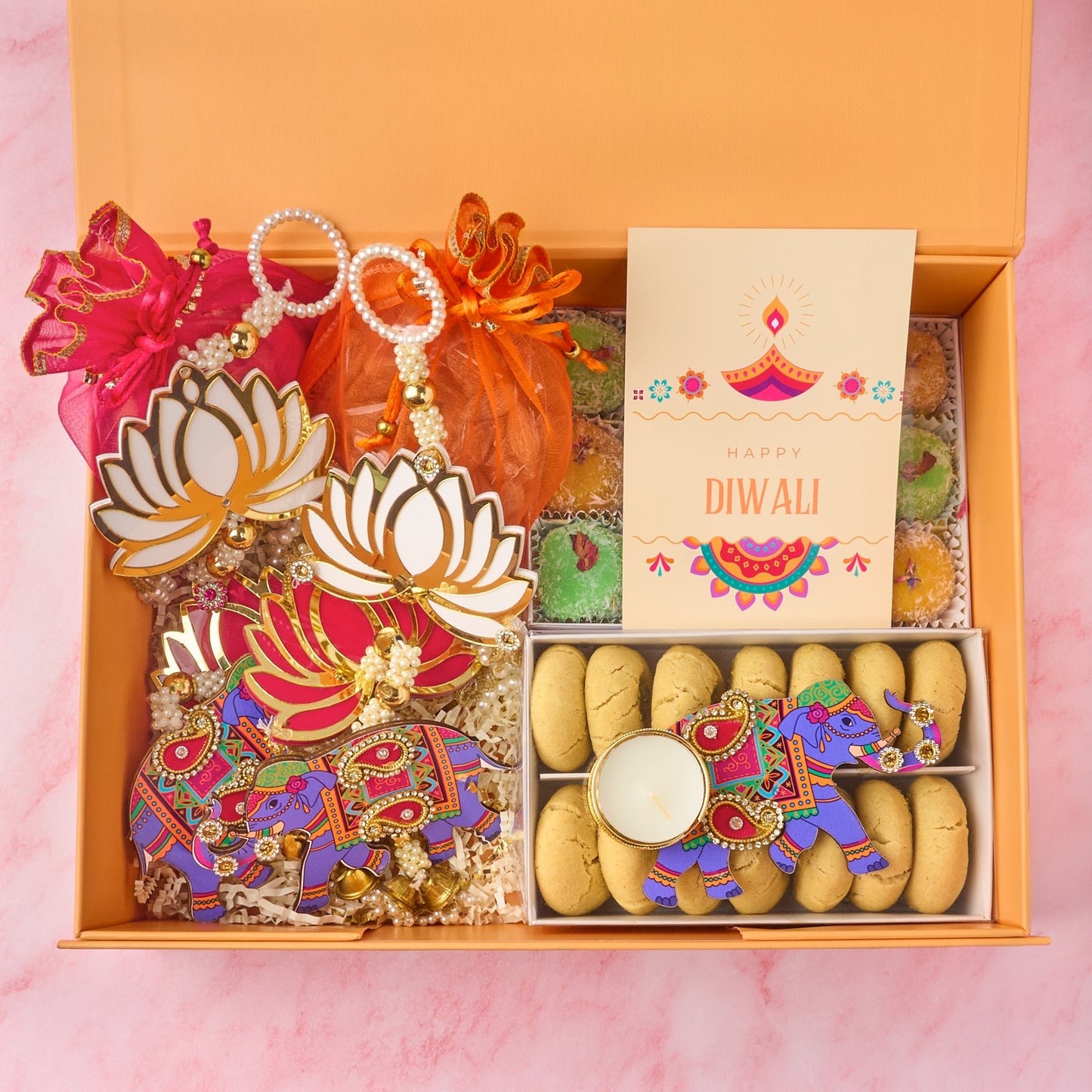 Amara Diwali gift box with two potli bags, laddoos, nankhatai, elephant tealight holder and wall hangings