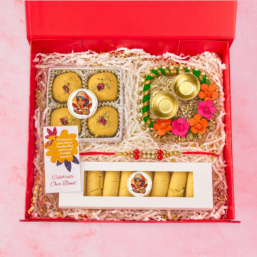 Open red Rakhi gift hamper with 4 Besan Laddoos, 8 Nankhatai biscuits, floral roli chawal plate, Red Crystal Rakhi and Celebration card