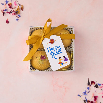 Besan Laddoo 4 Pc Box with gold-coloured ribbon and Happy Rakhi tag