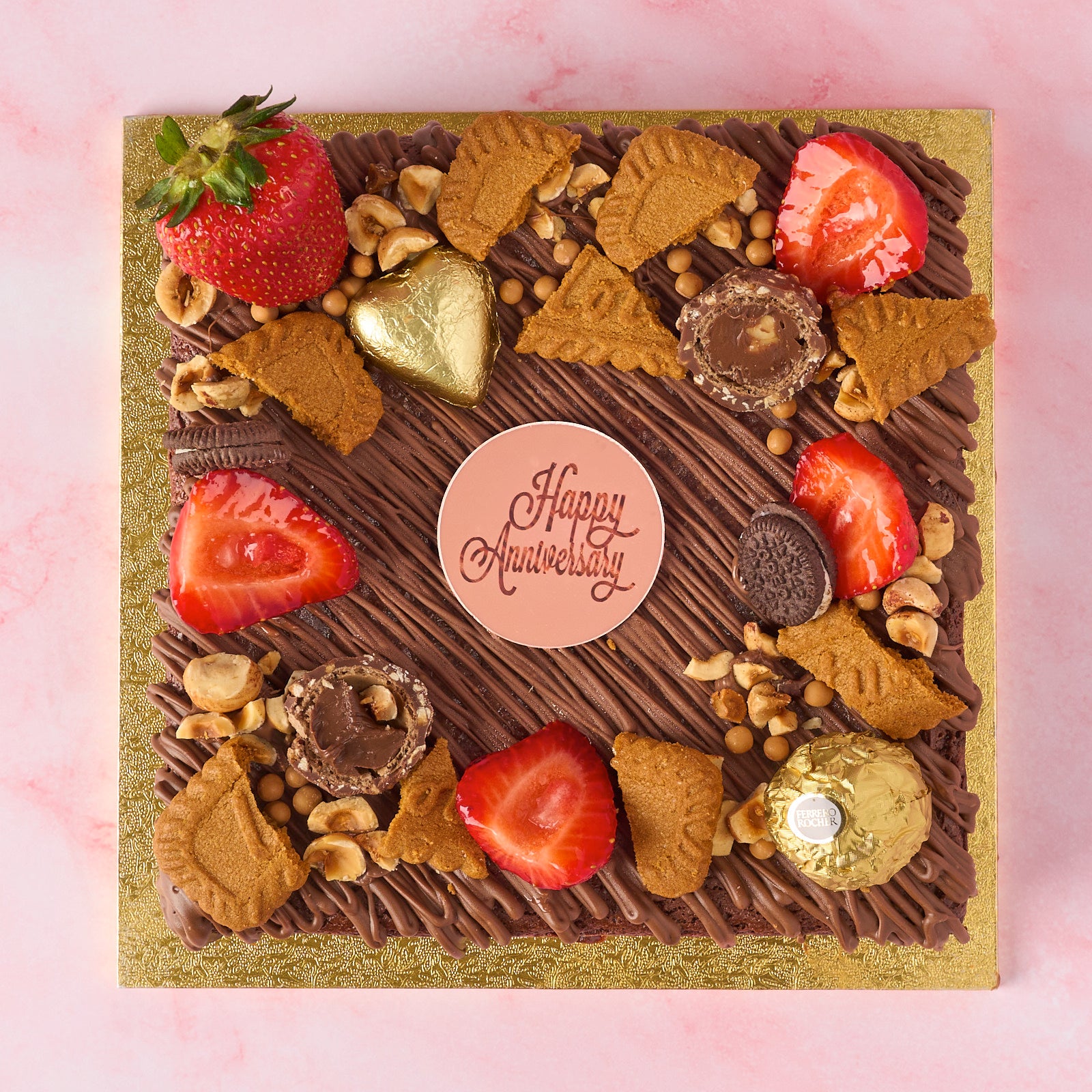 Eggless Belgian chocolate brownie cake decorated with strawberries, chocolates and Happy Anniversary cake charm.