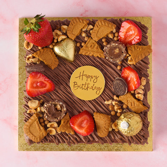 Eggless brownie cake made with real Belgian chocolate, topped with strawberries, Biscoff, Ferrero Rocher and Happy Birthday cake charm.