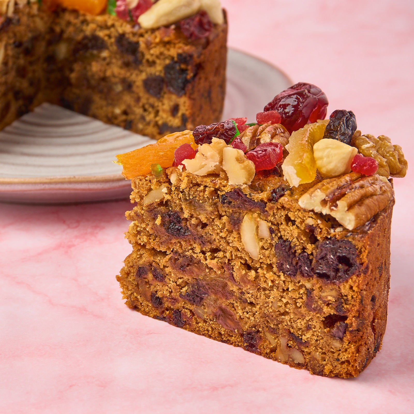 Close-up of moist Christmas plum cake slice showing fruits and nuts in the eggless alcohol-free cake