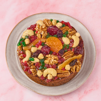 Top view of eggless Christmas fruit cake decorated with cashews, walnuts, pecans, apricots and glazed fruits