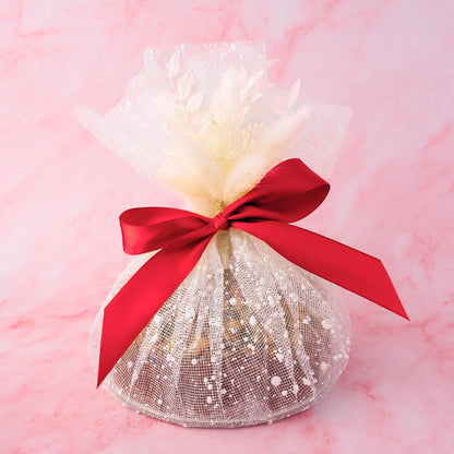 Eggless Cake gift wrapped in decorative net wrap with red ribbon by EatWithSimer