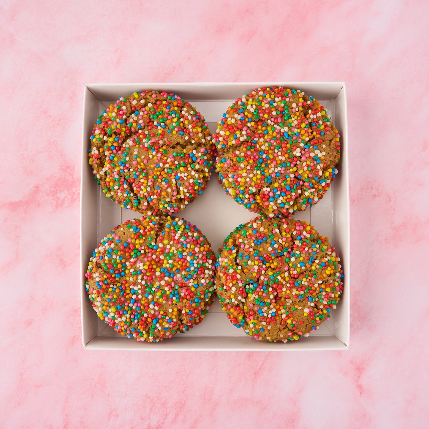 Open box of funfetti cookies showing colourful sprinkle-covered eggless cookies