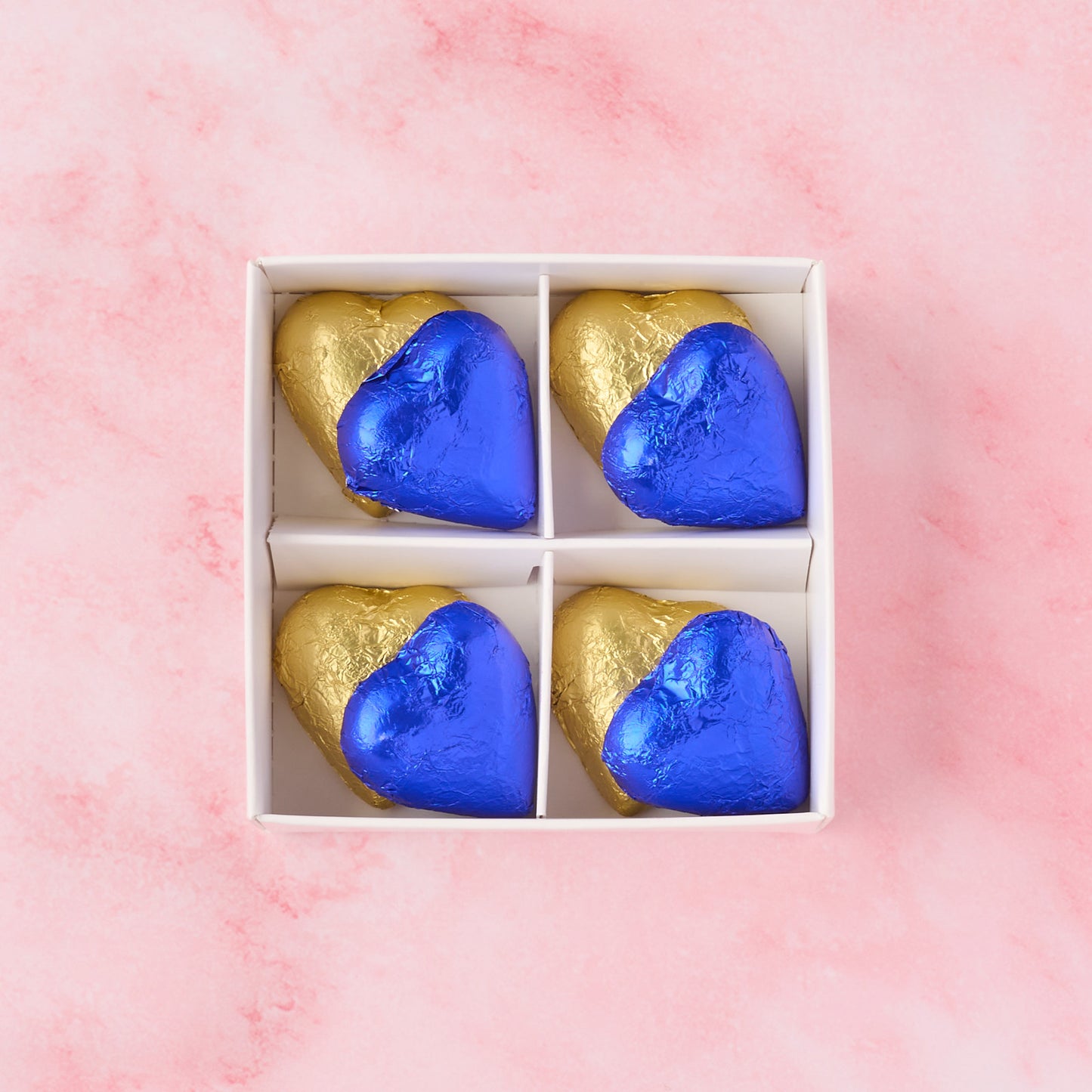 Open blue and gold heart chocolate box showing 8 heart-shaped chocolates, chocolate gift box ideal for baby boy showers, newborn gifting and hampers