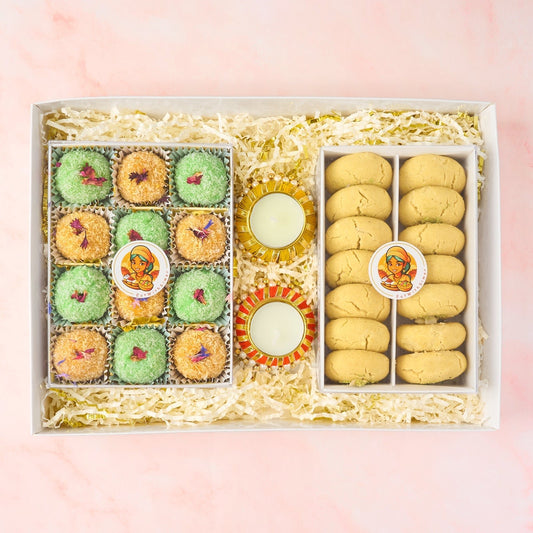 Indian sweets and cookies gift box with laddoos, nankhatai biscuits and decorative tealight holders