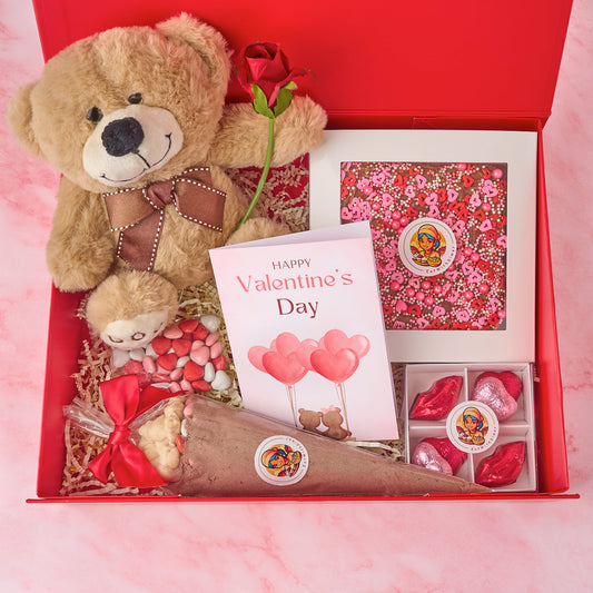 Love hamper chocolate gift box with heart-themed brownies, chocolates, teddy, rose, cocoa mix and greeting card, packed in a red magnetic box