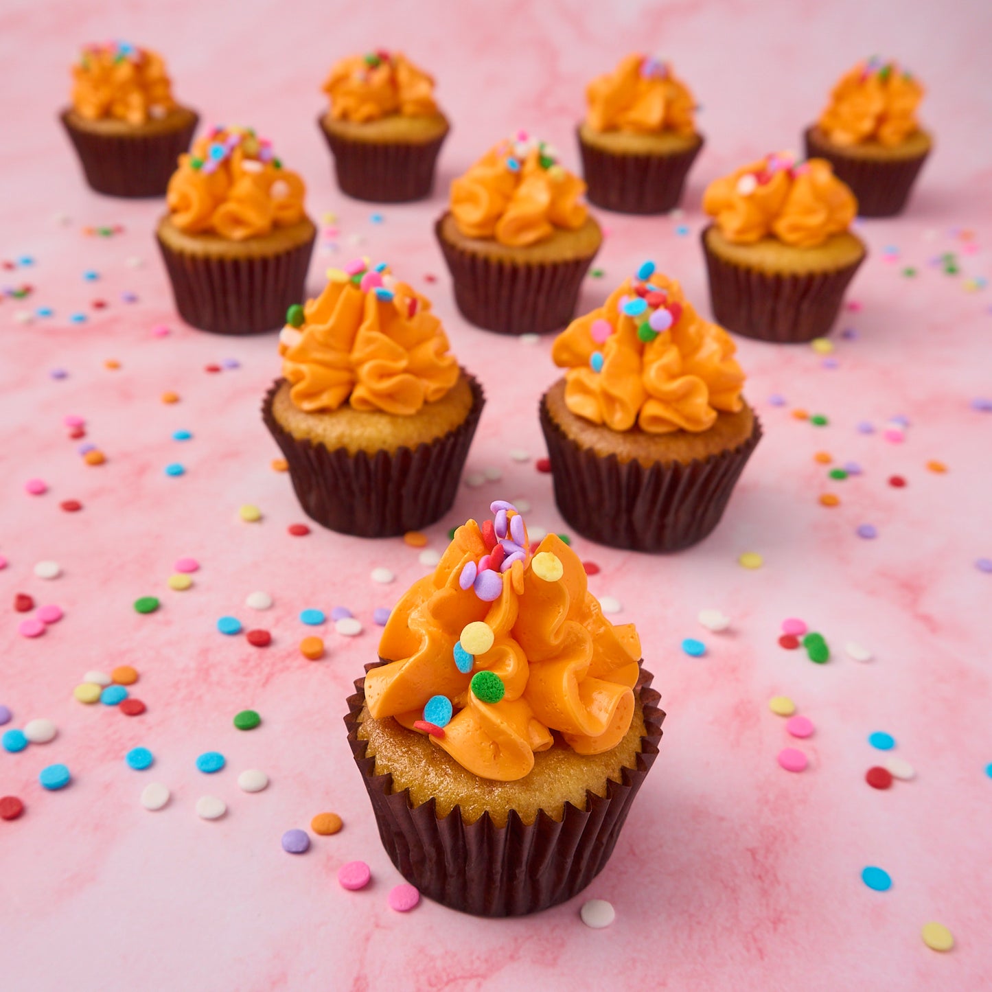 Close-up of mini eggless cupcakes with vanilla buttercream frosting and colourful sprinkles, baked fresh in Sydney