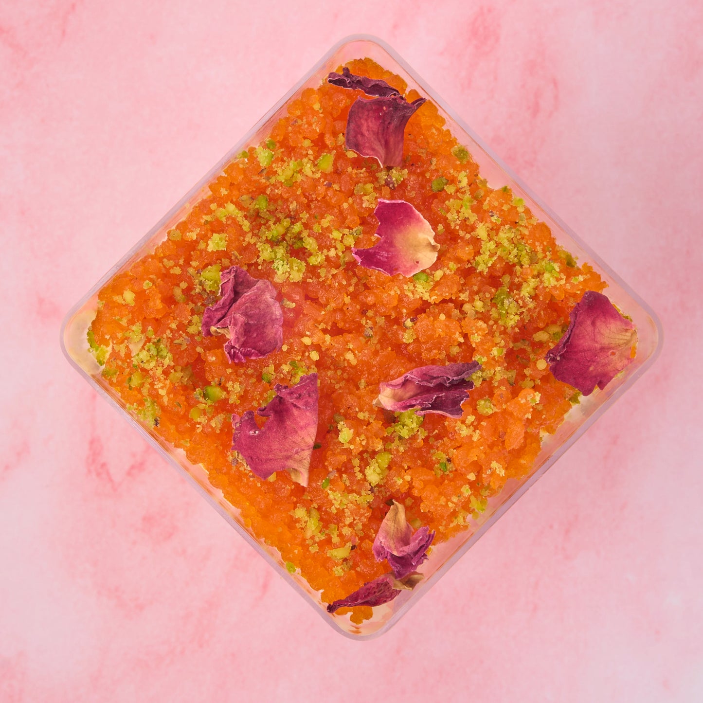 Top view of Motichoor Cheesecake Mousse Cup with rose petals and motichoor laddoo topping