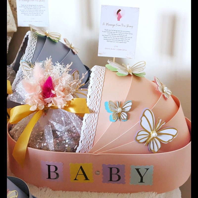 Pink new baby bassinet gift hamper with eggless Pistachio Mawa Cake and personalised message card