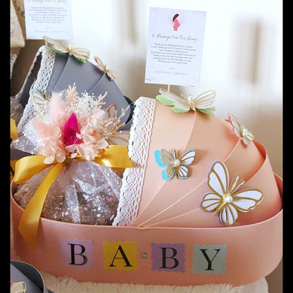 Pink new baby bassinet gift hamper with eggless Pistachio Mawa Cake and personalised message card