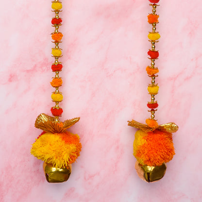 Orange and yellow wall hangings with pom pom details and gold accents