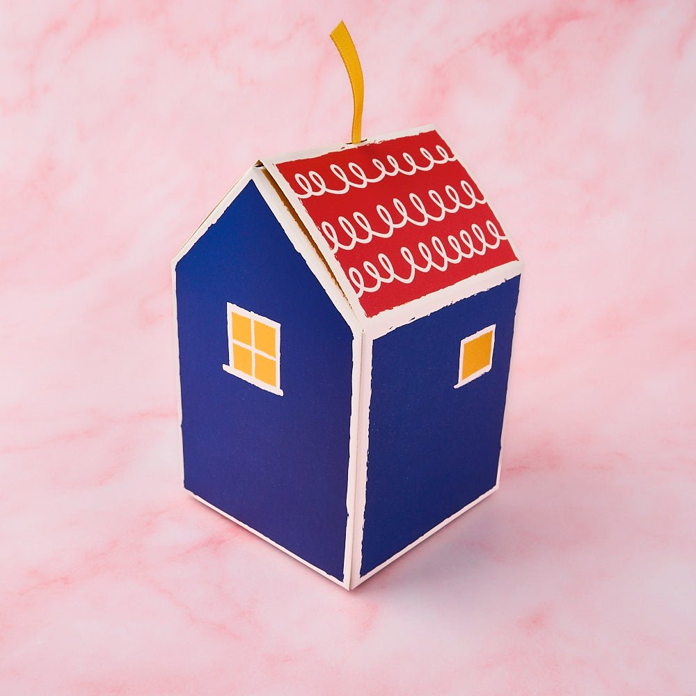 Return gift for housewarming with assorted Indian sweets in a decorative house gift box